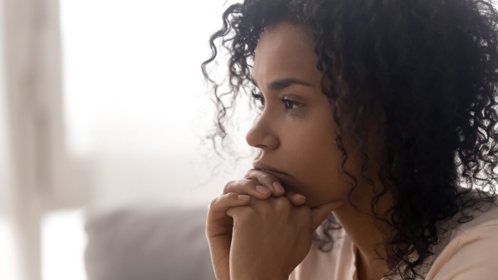 Woman of colour looking anxious, needing the 333 Calming Rule for anxiety relief